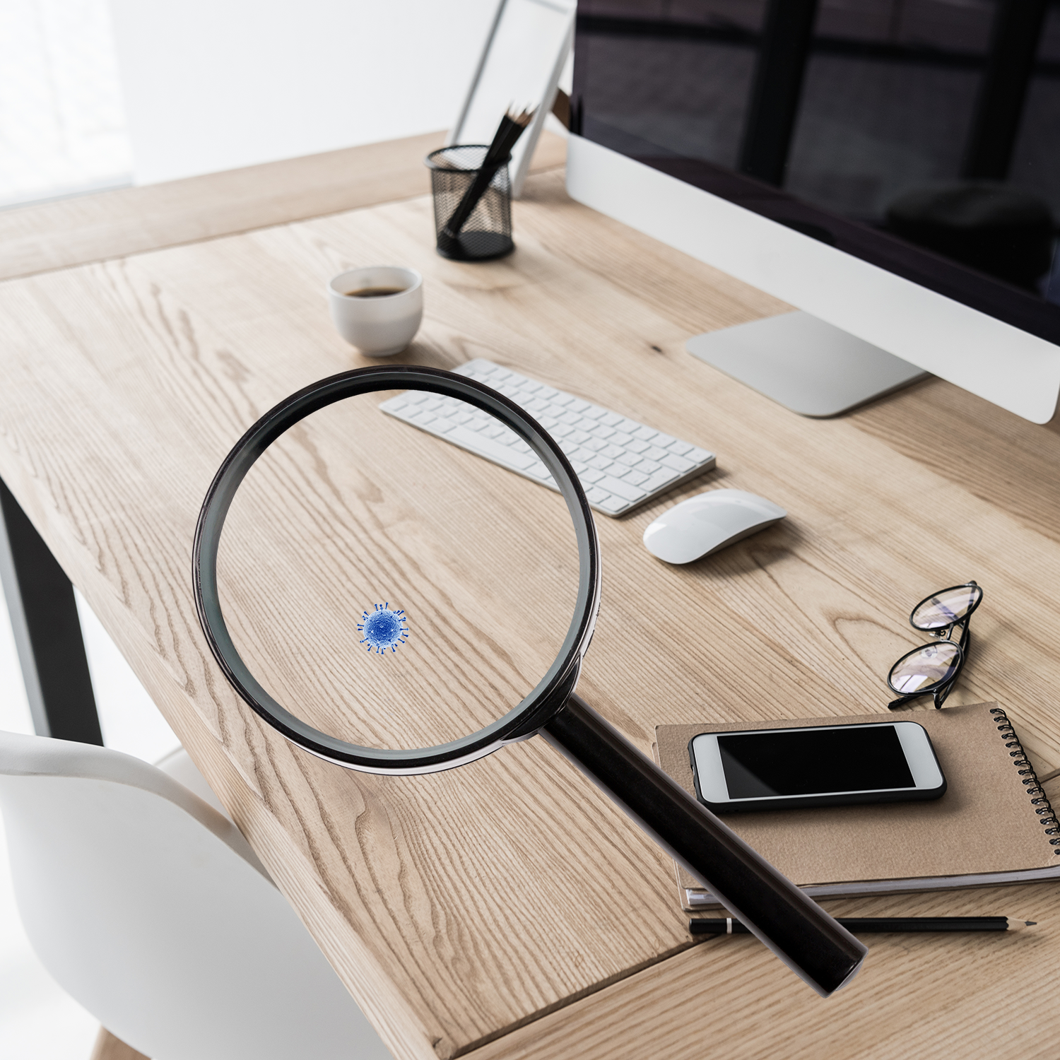 A magnifying glass over a desktop showing a single germ on the surface.