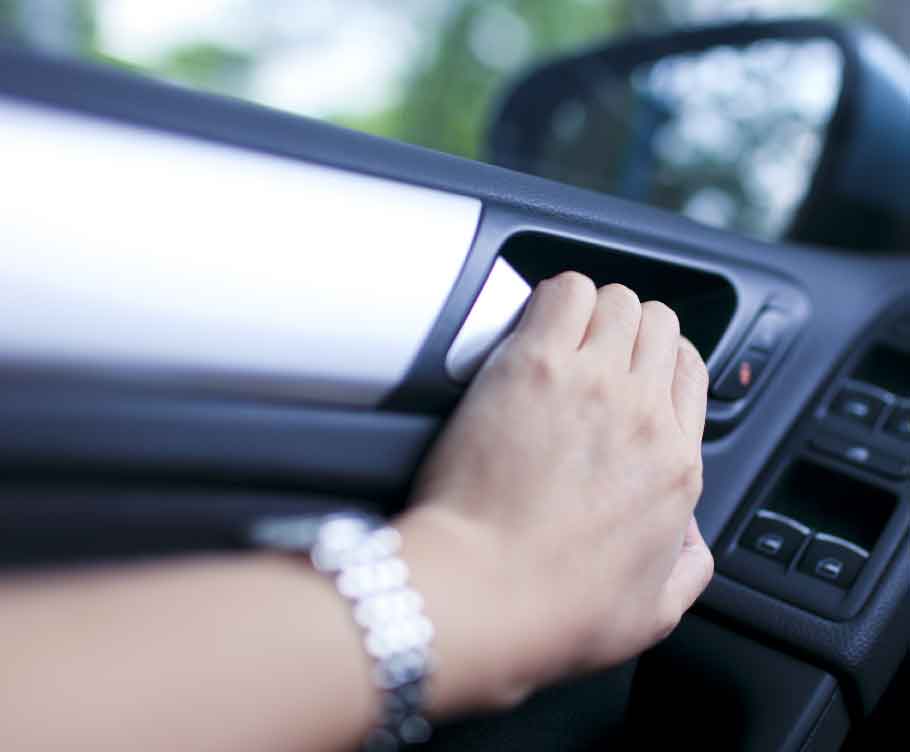 a person pulling on the interior handle of a car door, highlighting how many car surfaces can be germ-filled and could benefit from treatment with permasafe automotive products