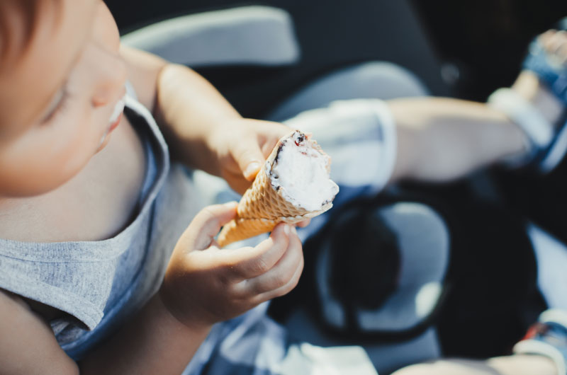 a child inside a car eating an ice cream highlighting that permasafe automotive disinfection is safe enough for children