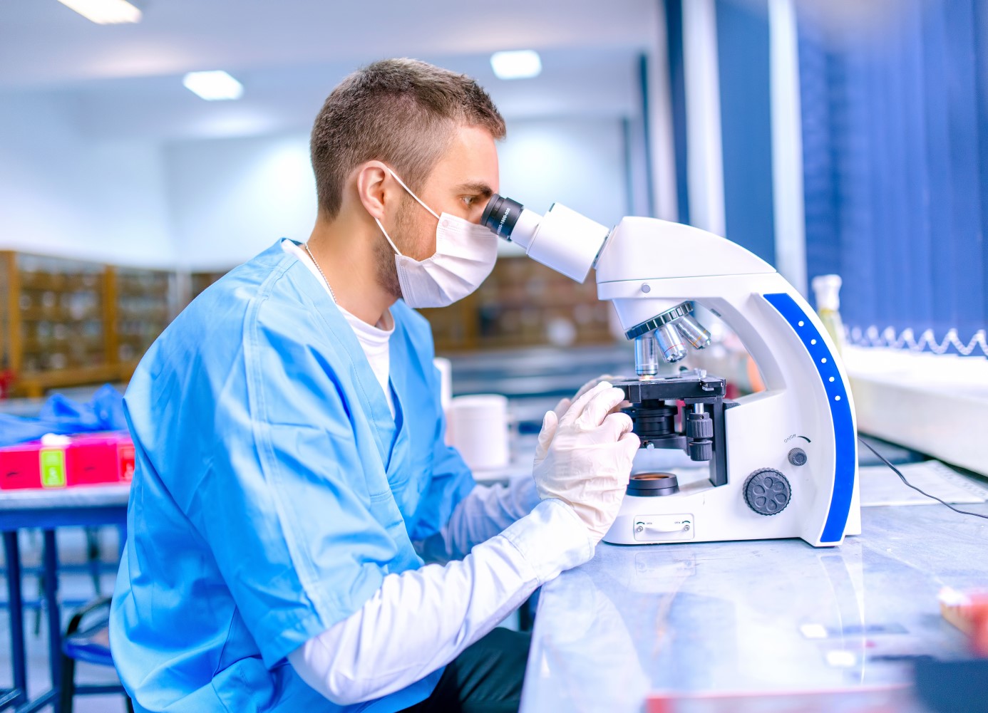 scientist at microscope looking at microbes